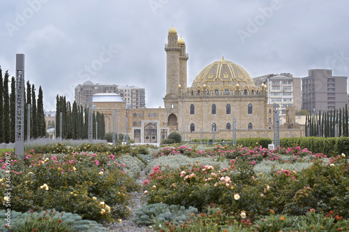Mosque in the city of Baku during the flowering of rose bushes