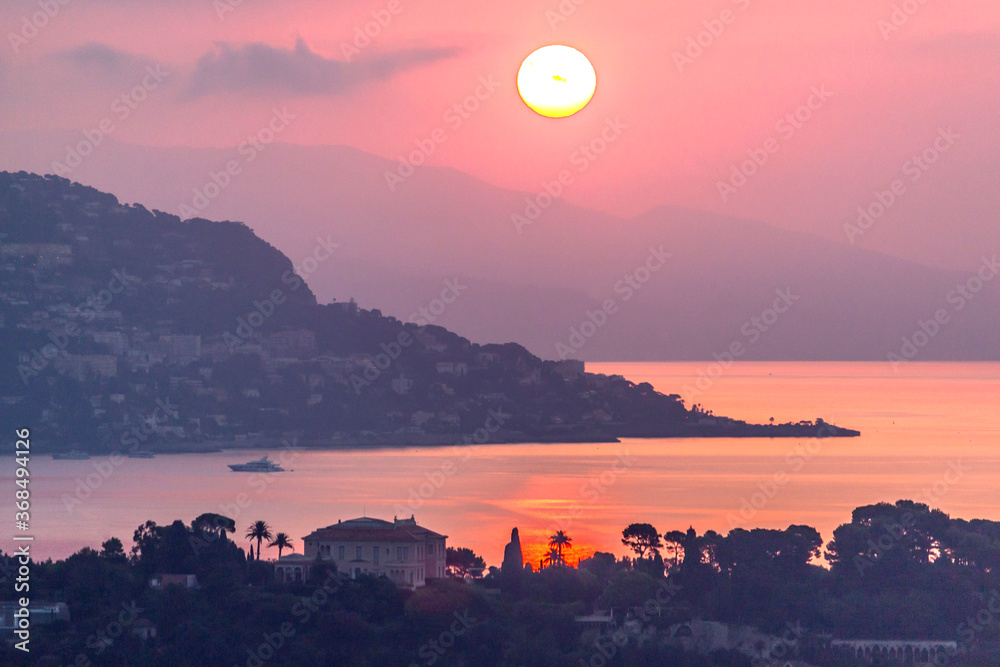 Fototapeta premium Lever de soleil flamboyant sur la baie des fourmis, la baie de Villefranche sur Mer et la presqu'île du Cap Ferrat