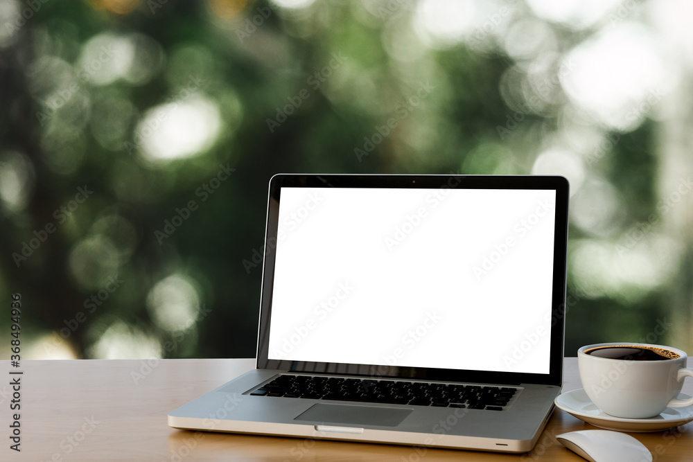 laptop with coffee cup on the table,background for light bokeh.