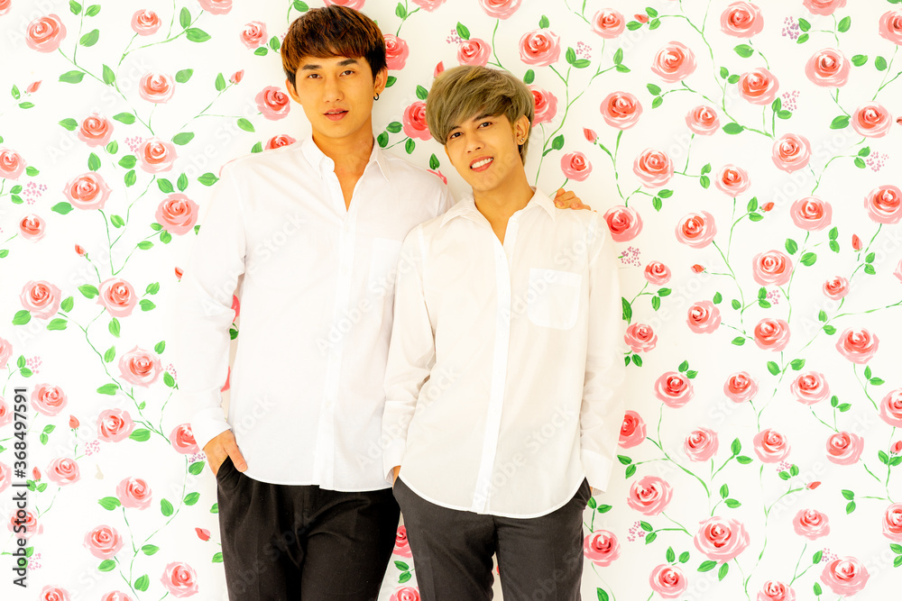 young Gay lover Asian men were happy together over rose background . LGBT gay couple love concept. young Gay lover Asian men were happy together over rose background . LGBT gay couple love concept.