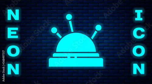 Glowing neon Needle bed and needles icon isolated on brick wall background. Handmade and sewing theme. Vector Illustration.