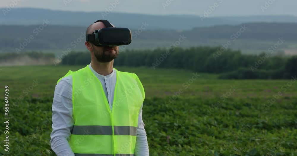 Farm specialist engineer using technology VR monitoring harvest working for agriculture productivity at large wheat field Farm specialist engineer using technology VR monitoring harvest working for agriculture productivity at large wheat field