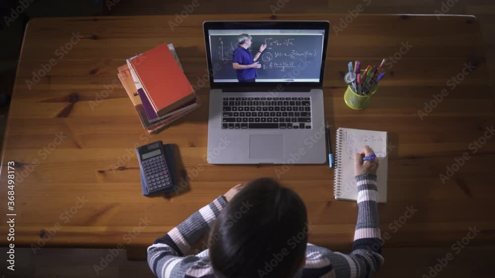 Student learning through educational video call with Math Teacher on laptop. Online e-learning due to coronavirus pandemic