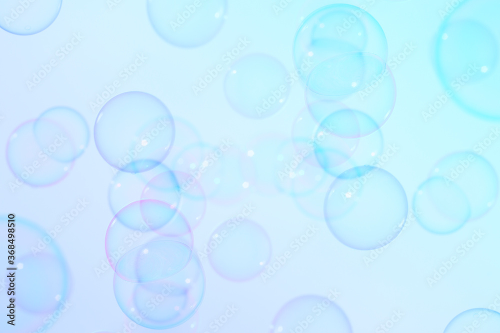 Clear transparent blue soap bubbles float background.