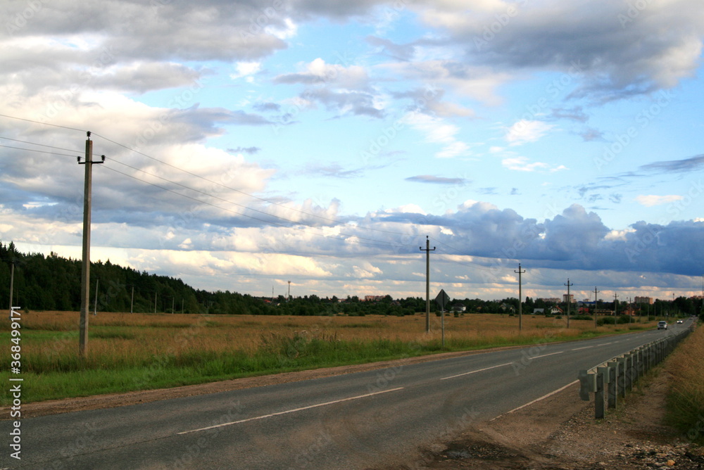 landscape road to the field, forest and Cumulus clouds