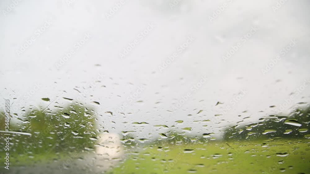 Movement of Rain falling on car windshield,drive car on street in city at heavy rain storm,blurred traffic light. Movement of Rain falling on car windshield,drive car on street in city at heavy rain storm,blurred traffic light.