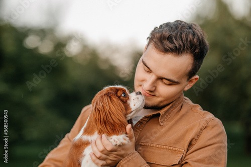 king charles spaniel in the arms of a man