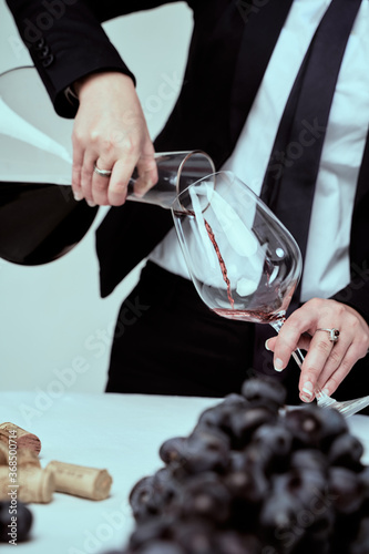 Sommelier pours red wine into a glass