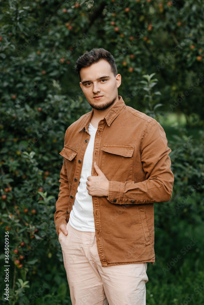 Fototapeta premium Portrait of happy young hipster man thinking in park