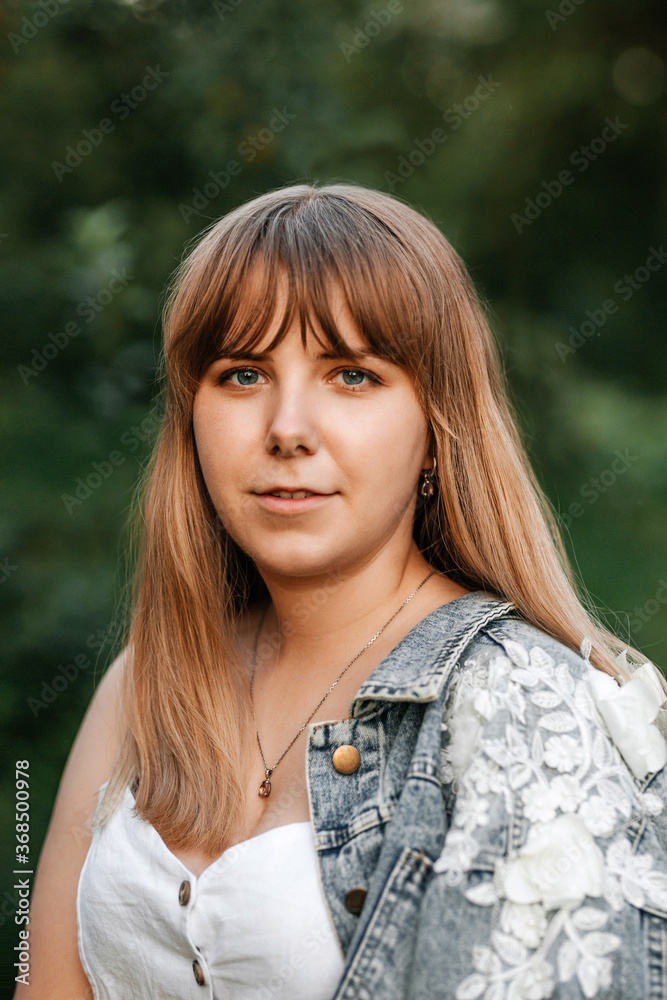 Young cheerful woman with long blonde hair outdoors in a park Young cheerful woman with long blonde hair outdoors in a park