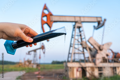 oil industry. a test tube with crude oil in the hand of an engineer