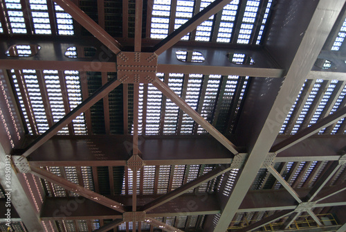 Looking up at the underside of a steel bridge.