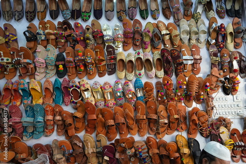 Traditional mojari shoes (Juttis) of various designs on display. These are shoes made from leather and decorated with various elements for royalty. Indian Traditional Shoes.