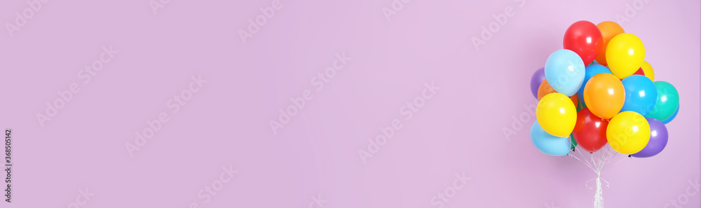 Bunch of bright balloons on lavender background, space for text. Banner design Bunch of bright balloons on lavender background, space for text. Banner design