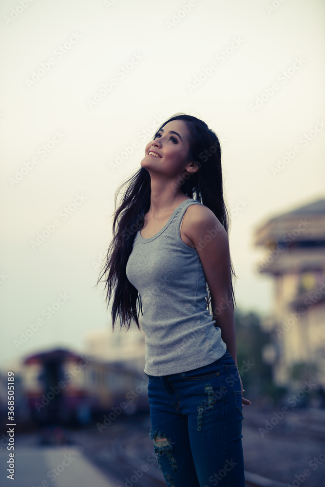 Happy young beautiful Asian woman at the railway station Happy young beautiful Asian woman at the railway station