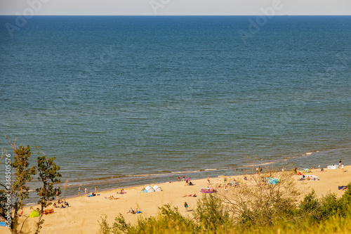 Fototapeta Naklejka Na Ścianę i Meble -  view from the escarpment to the beach on the Baltic Sea on a summer day with people