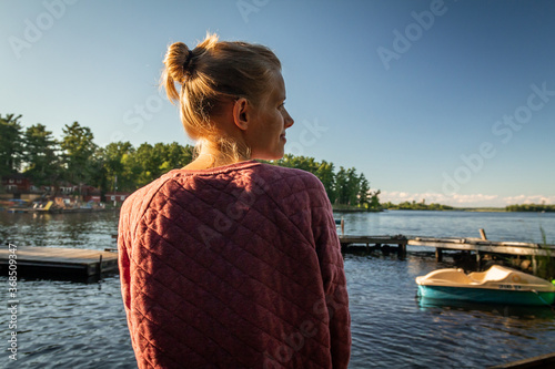 Woman sitting on dock, looking out at Lake Kabetogama in Voyageurs National Park, Minnesota photo