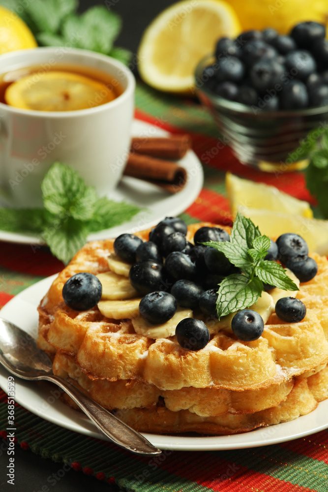 Belgian waffles with blueberry and a cup of tea with lemon