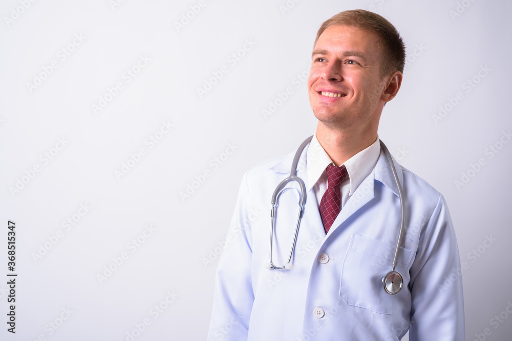 Portrait of handsome man doctor against white background
