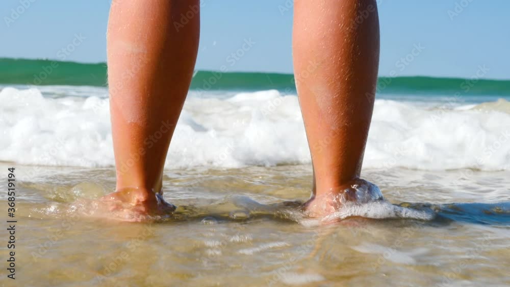 sea foam, waves and child foot on a sand beach sea foam, waves and child foot on a sand beach