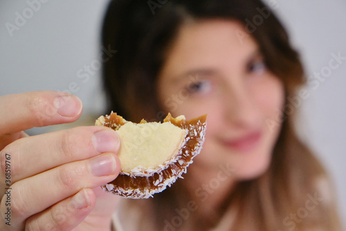 woman eating cornstarch alfajor and drinking yerba mate infusion