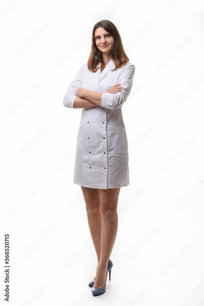 A girl in white uniform stands with her arms folded on her chest against a white background