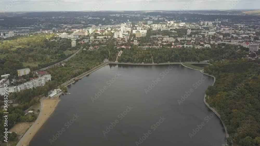 Aerial view of a lake in a park with autumn trees. Kishinev, Moldova. Epic aerial flight over water. Colorful autumn trees in the daytime. Drone flies along a lake with yellow trees. Drone Shot 4K. Aerial view of a lake in a park with autumn trees. Kishinev, Moldova. Epic aerial flight over water. Colorful autumn trees in the daytime. Drone flies along a lake with yellow trees. Drone Shot 4K.