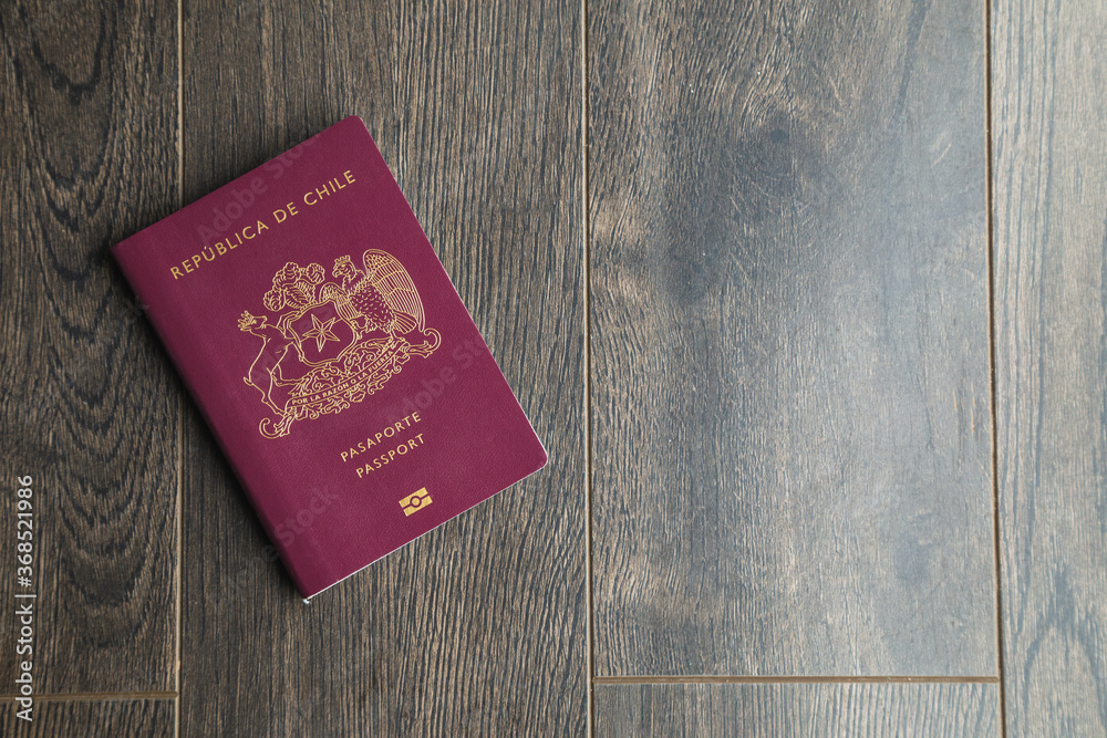 A Red Chilean passport with some dollars on a desk A Red Chilean passport with some dollars on a desk