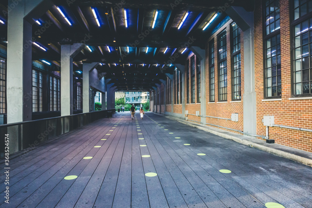 Fototapeta premium Walking through a tunnel on High Line with dots on the floor for social distancing