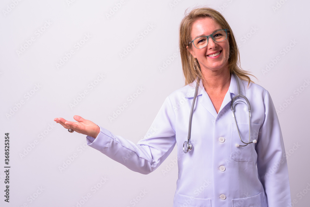 Mature beautiful blonde woman doctor against white background Mature beautiful blonde woman doctor against white background