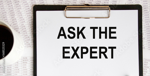 The inscription on the paper tablet: ask the experts. next to accounting and a mug of coffee.