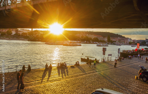 Photography People sitting and walking along  Vltava river in Prague - awe July in capital o