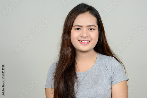 Portrait of happy young beautiful Asian woman