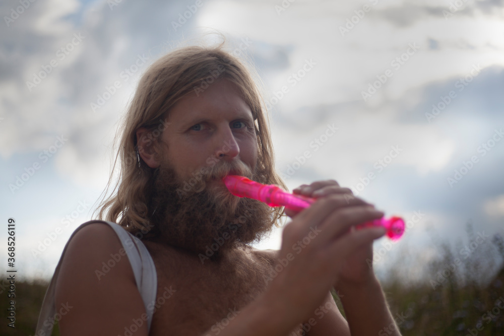 The traveler plays the flute. A guy with a big beard. The man travels in nature. The traveler plays the flute. A guy with a big beard. The man travels in nature.