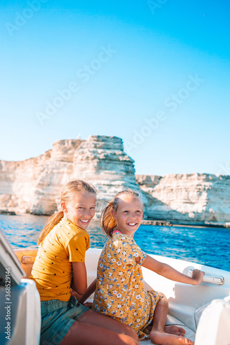 Little girls sailing on boat in clear open sea photo