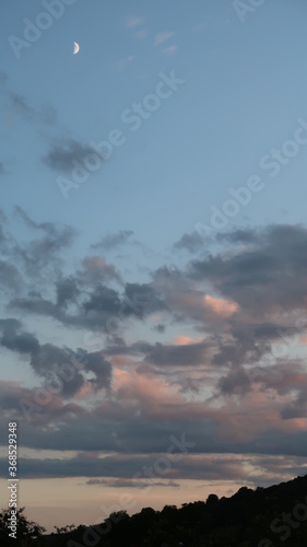 beautiful sunset clouds with crescent moon in the mountains 