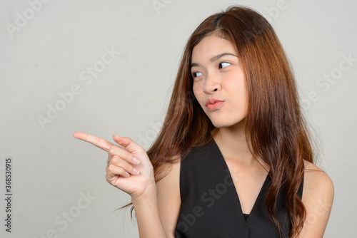 Portrait of young beautiful Asian woman against white background