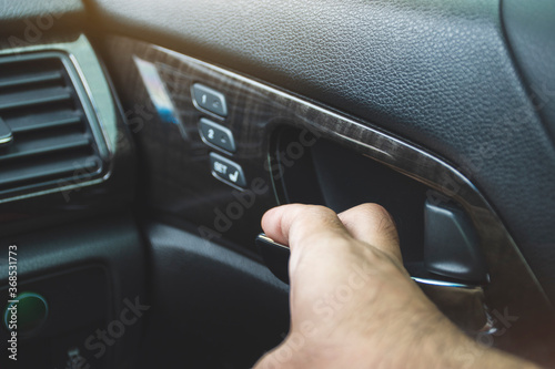 Driver man is opening car door handle in a car