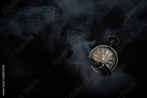 Watch vintage pocket  with smoke on black background.