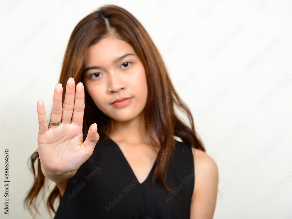 Portrait of young beautiful Asian woman against white background Portrait of young beautiful Asian woman against white background