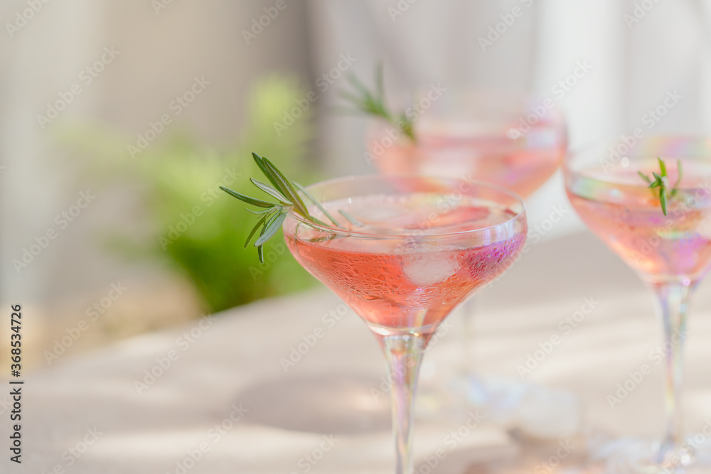 Fresh strawberry cocktail. Summer pink cocktail with strawberry and ice cubes on light beige background mockup. Trendy shadows and sunlight background with copy space for text. Fresh strawberry cocktail. Summer pink cocktail with strawberry and ice cubes on light beige background mockup. Trendy shadows and sunlight background with copy space for text.