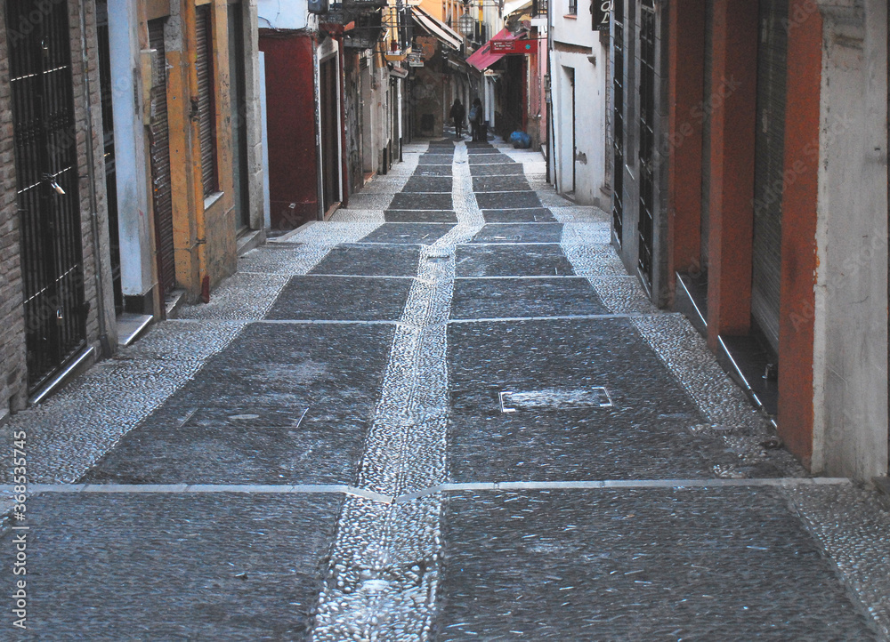 Spain- Granada- Down a Wet Street With Colorful Buildings Spain- Granada- Down a Wet Street With Colorful Buildings