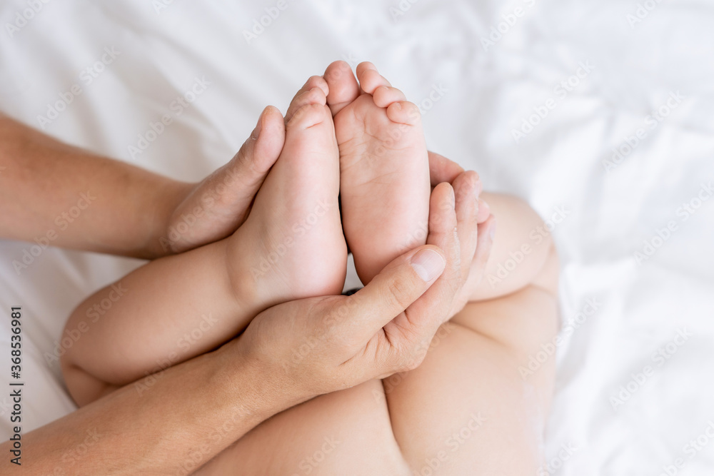 baby feet in daddy's hands