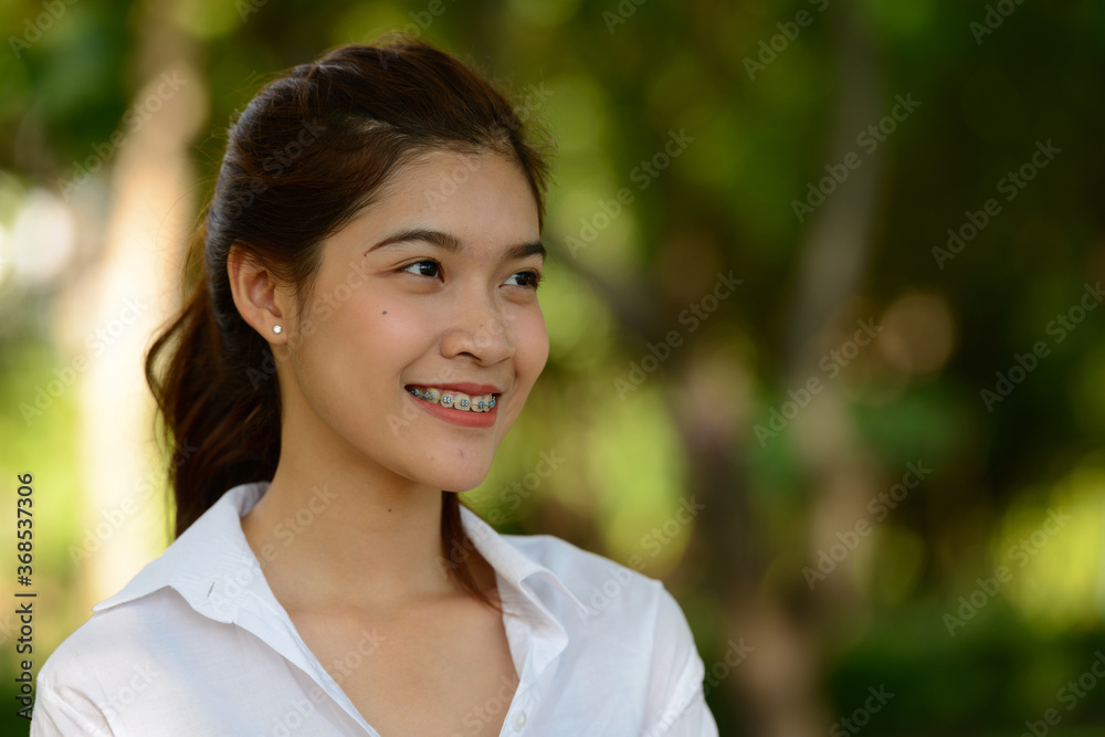 Young beautiful Asian woman at the park outdoors Young beautiful Asian woman at the park outdoors