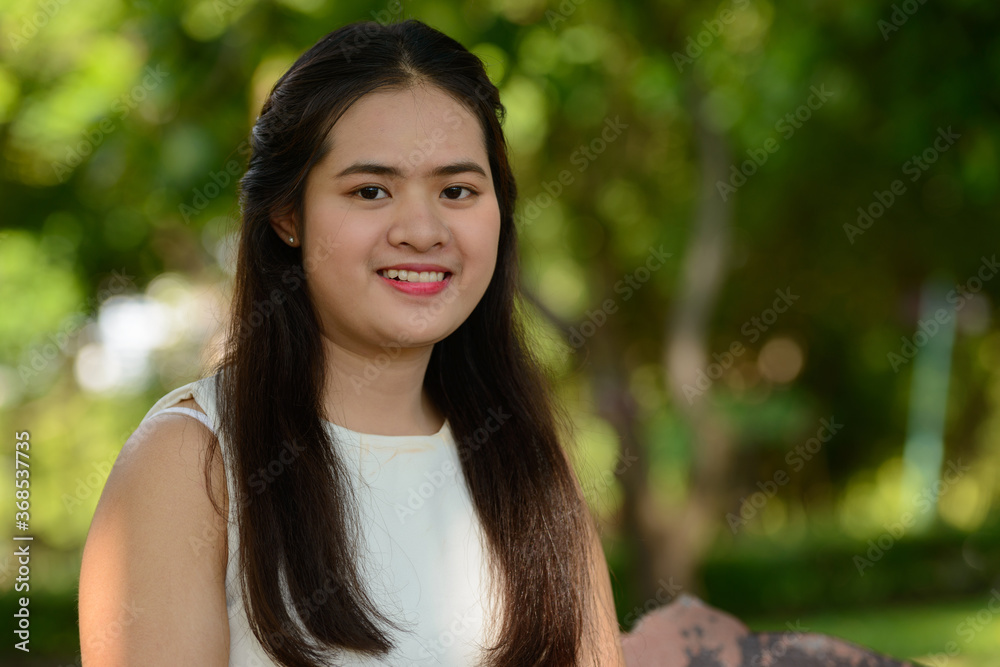 Young beautiful Asian woman at the park outdoors Young beautiful Asian woman at the park outdoors
