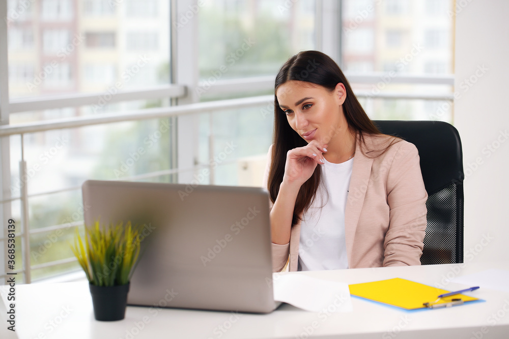 Attractive smiling young girl working on laptop computer Attractive smiling young girl working on laptop computer