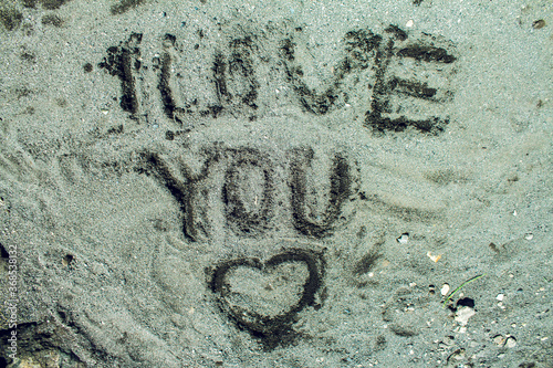 the word "I love you" and a heart in the sand