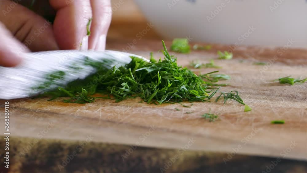 Cutting fresh dill on cutting board Cutting fresh dill on cutting board