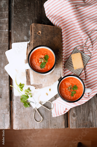 Vegetarian soup of ripe tomatoes in a white mug on wooden background. Healthy lifestyle, proper nutrition. Close-up, copy space