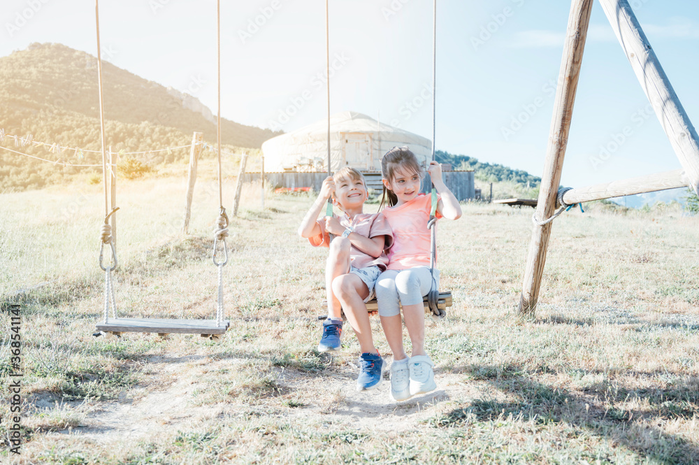 kids having fun and playing on the swings kids having fun and playing on the swings